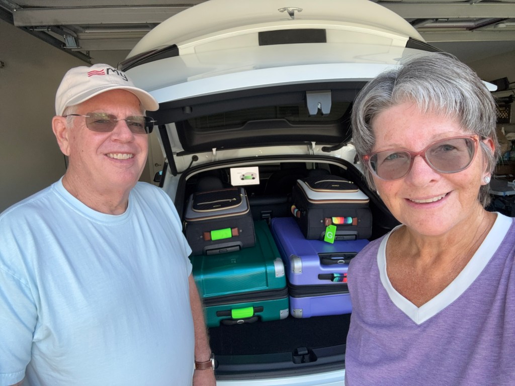 Jeannie and Skip standing beside their packed Tesla Model Y, Theo, before leaving home for their Panama Canal trip.